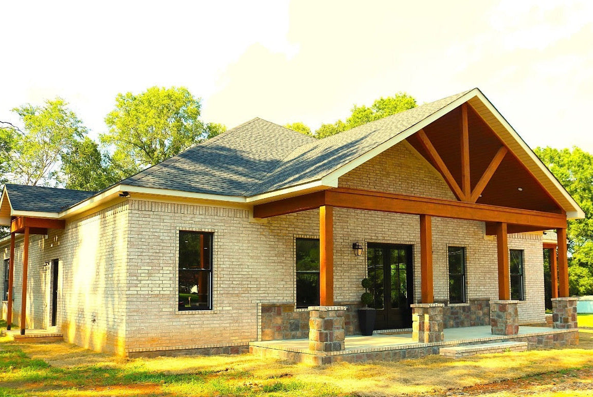 New house with brick exterior and wooden porch in a suburban setting